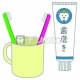歯ブラシ  コップにはいった二本の歯ブラシと歯みがき粉